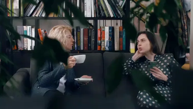 Two colleagues in warm, relaxed conversation.