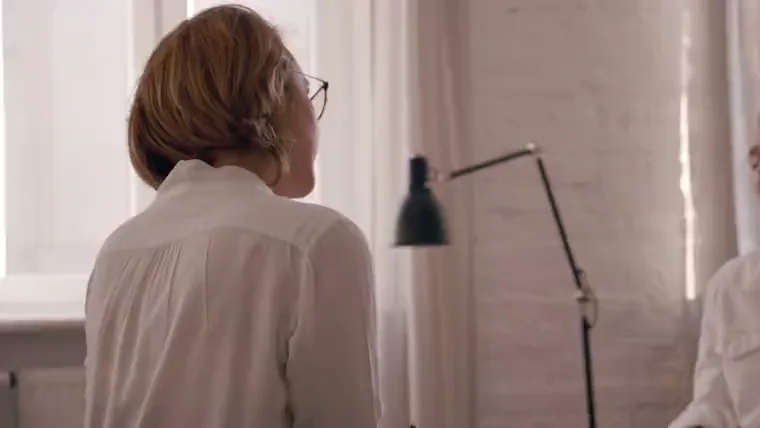 Two practitioners in an open, reflective conversation in a bright room.
